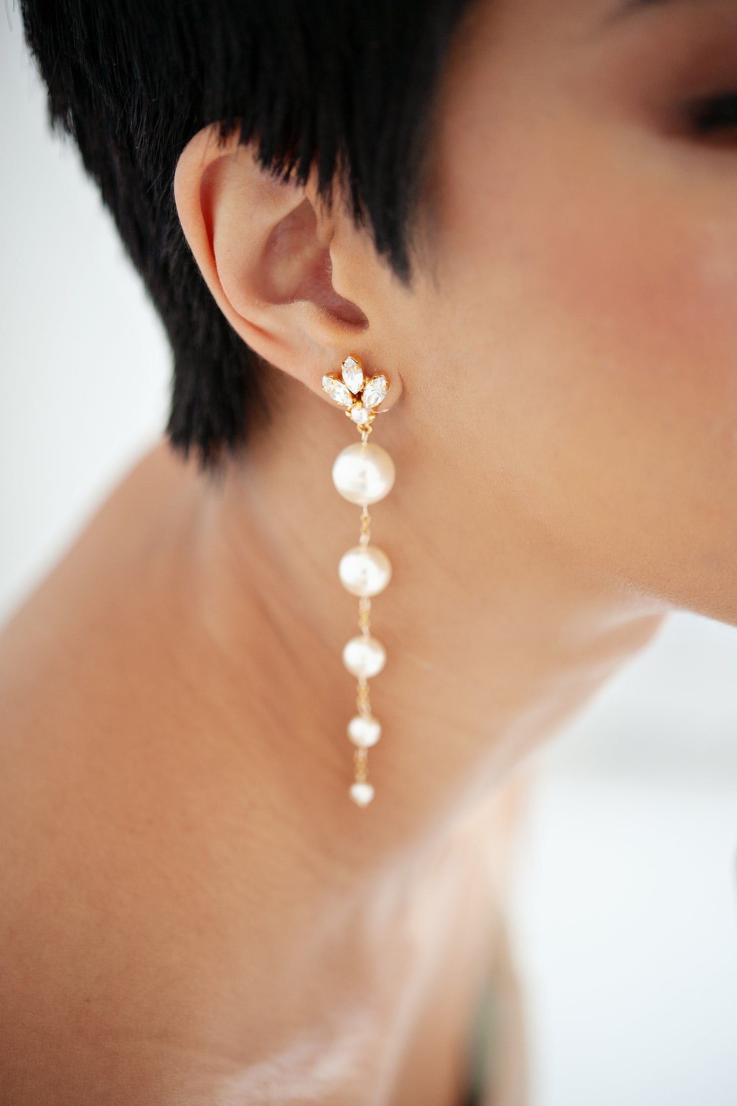 Bride wearing long pearl bridal statement earrings. 