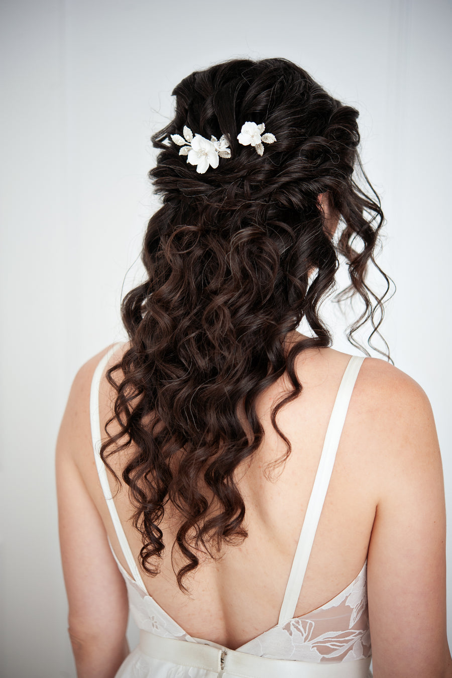 Bride with long half up half down hairstyle wearing silver bridal pins.