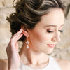 Bride with romantic updo wearing Swarovski Crystal Opal bridal earrings by Joanna Bisley Designs.