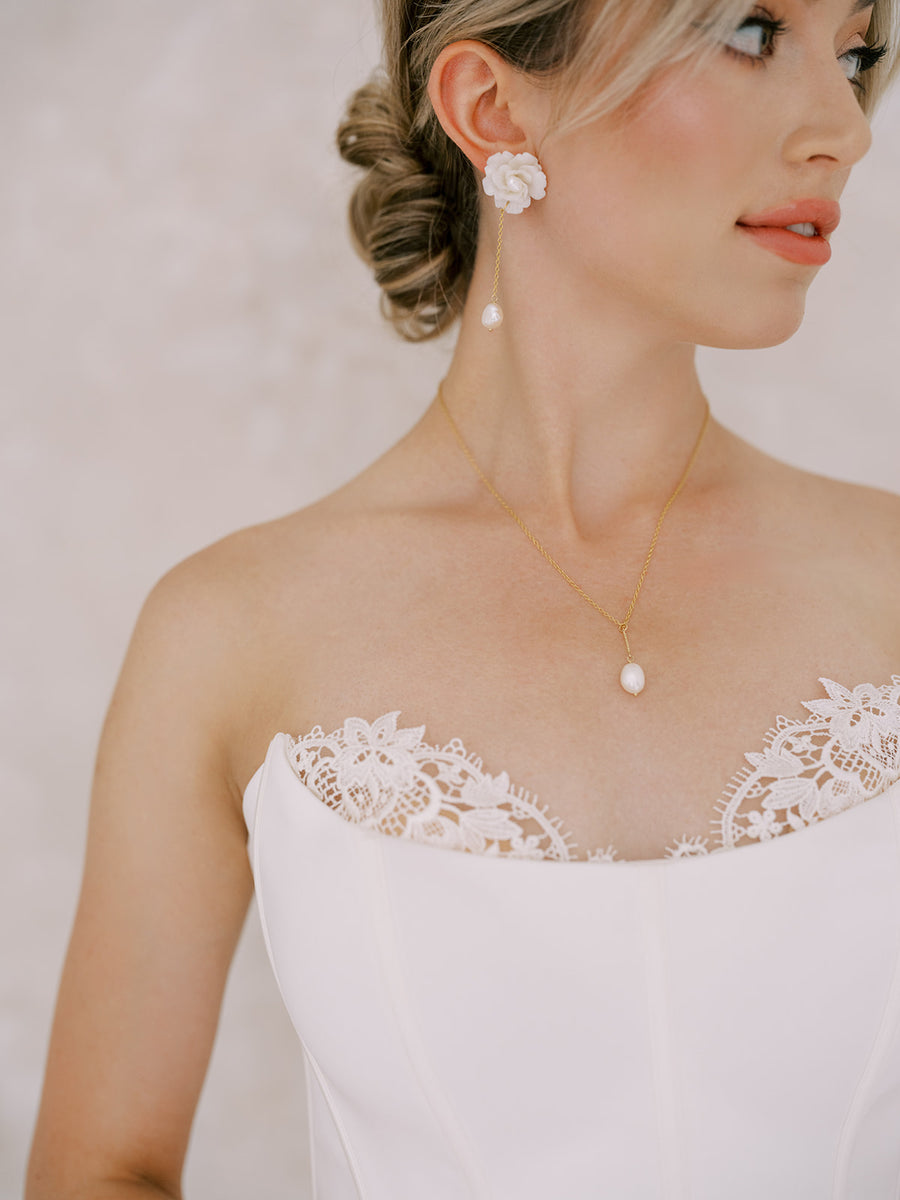 Bride wearing strapless bridal gown with matching pearl bridal necklace and earrings. 