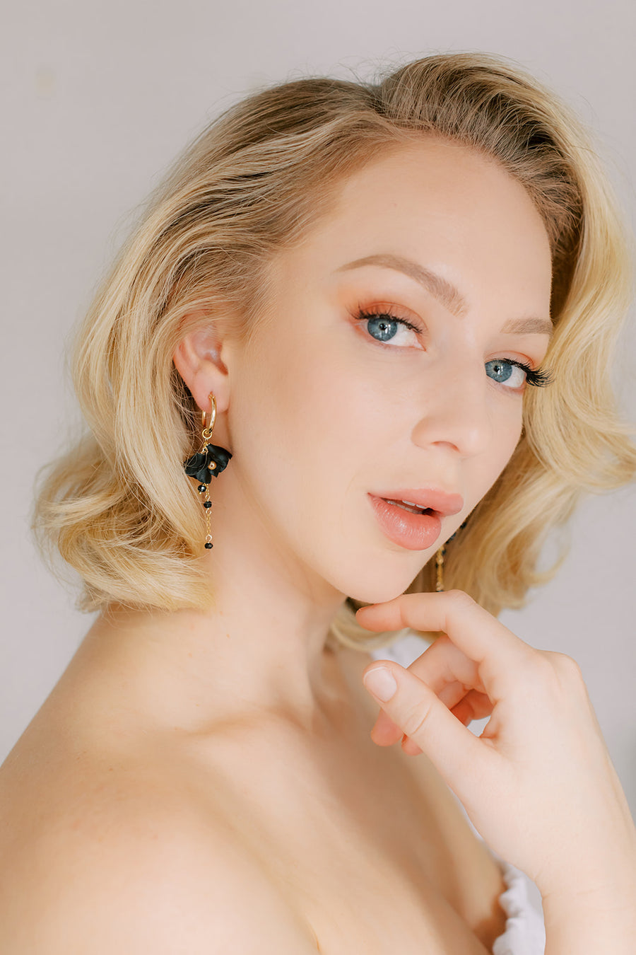 Blonde bride from Los Angeles wearing black and gold wedding earrings.