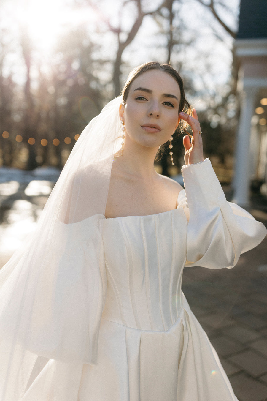 Bride outside wearing long pearl bridal earrings by Joanna Bisley Designs