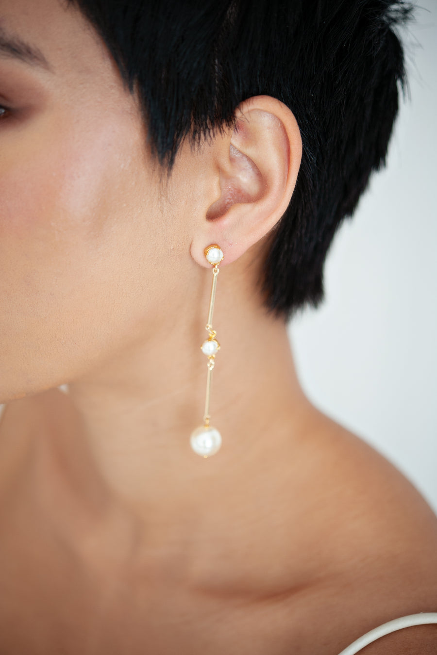  Bride wearing modern long pearl bridal earrings by Joanna Bisley  Designs. 