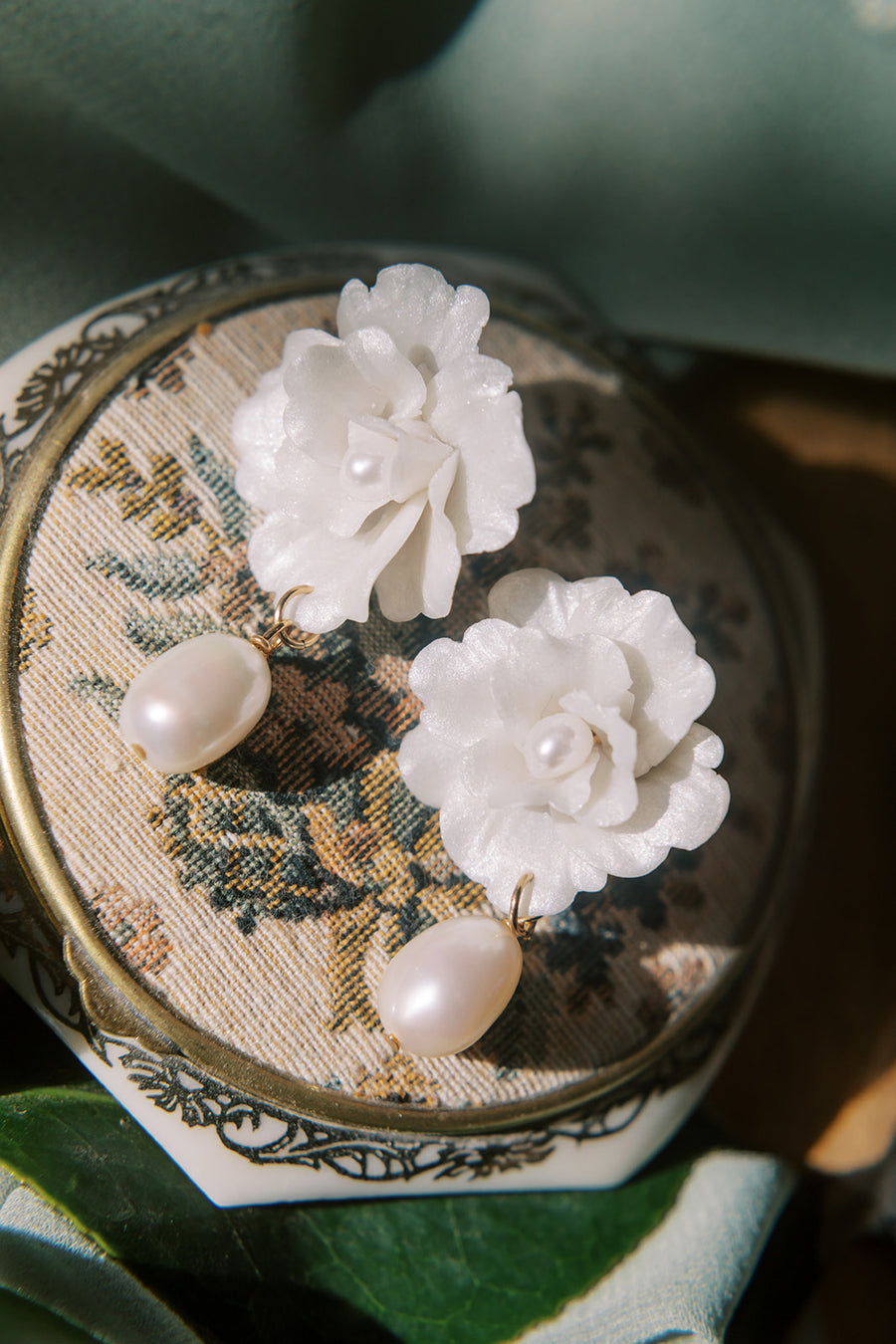 Close up of Julianne baroque pearl and flower bridal earrings.