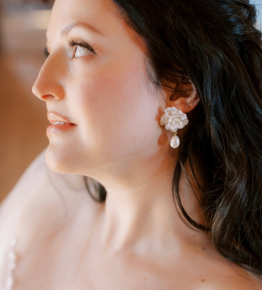A bride wearing floral bridal earrings with baroque pearl drop made by Joanna Bisley Designs.