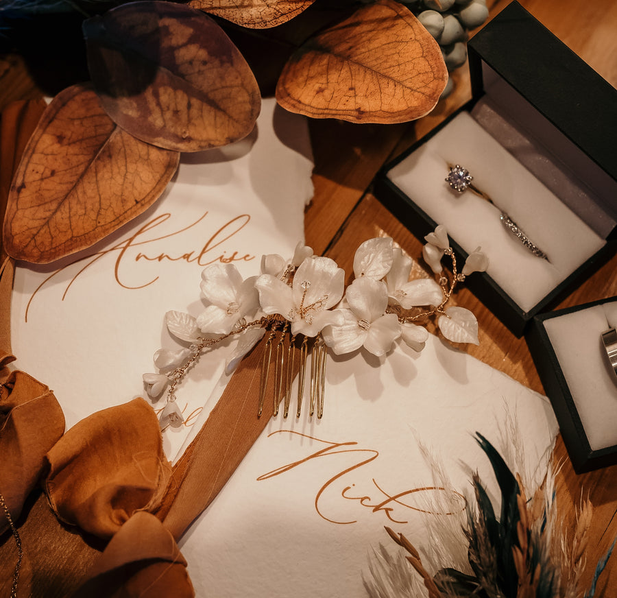 Bridal comb and wedding rings in a flat lay.