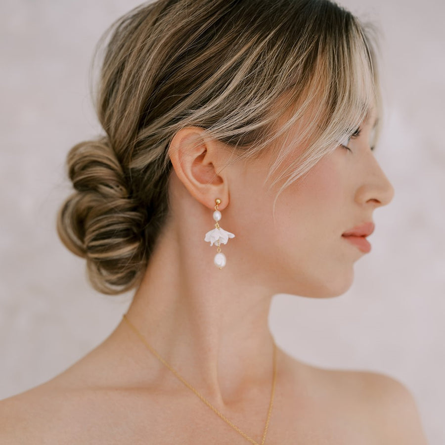 Bride wearing  delicate flower and pearl wedding earrings by Joanna Designs. 