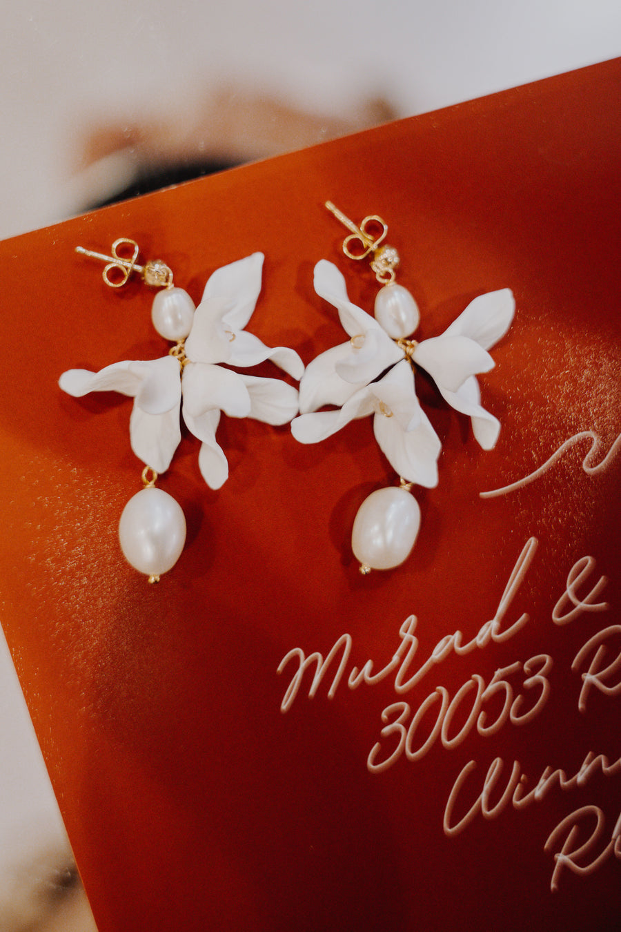 Baroque Pearl and Flower Earrings by Joanna Bisley Designs on a red background.