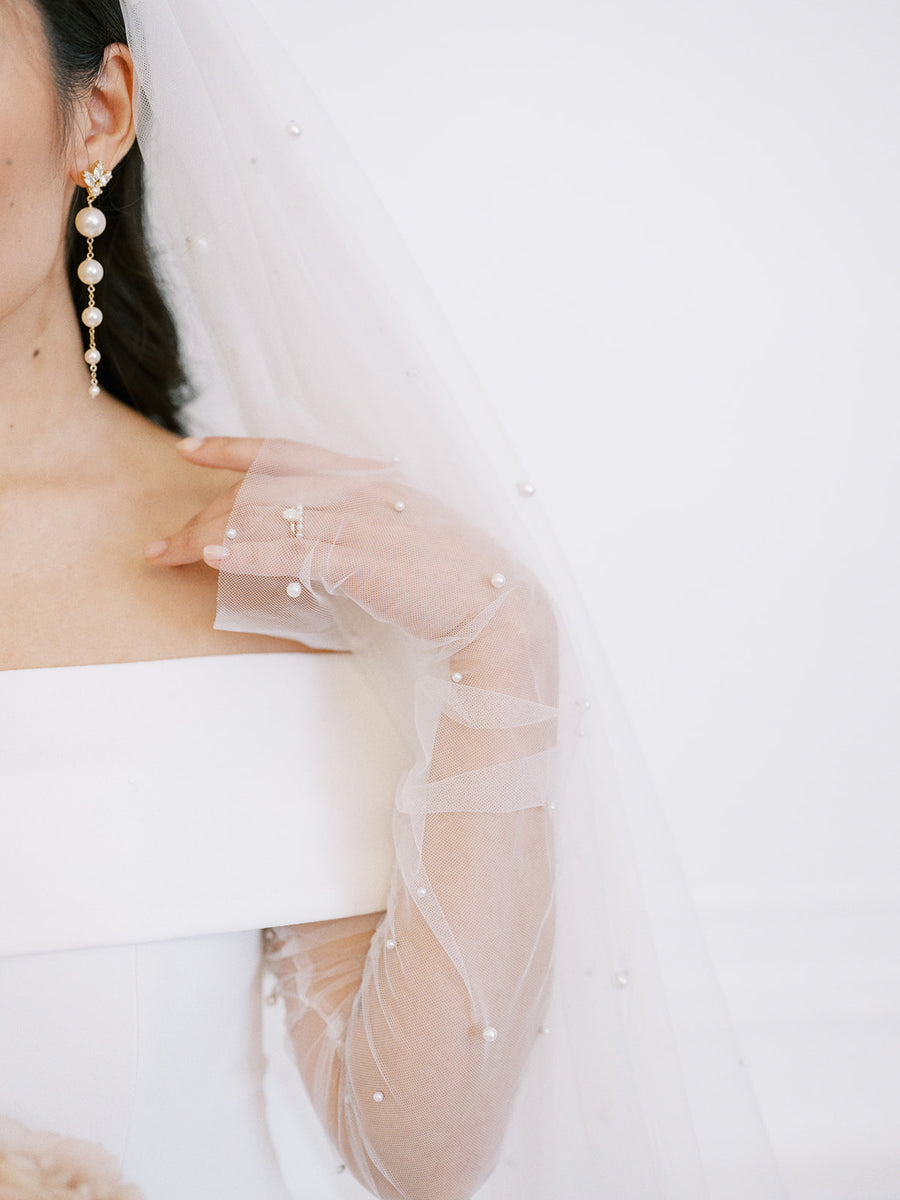 Bride wearing long pearl wedding earrings with a Swarovski Crystal stud at the top.