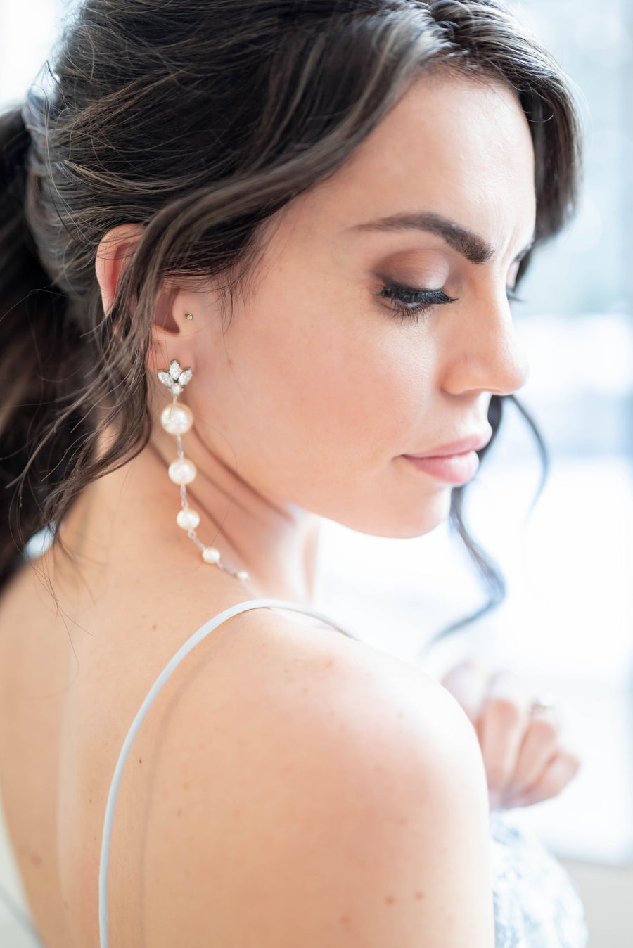 A side view of bride wearing vintage inspired  long pearl bridal earrings.