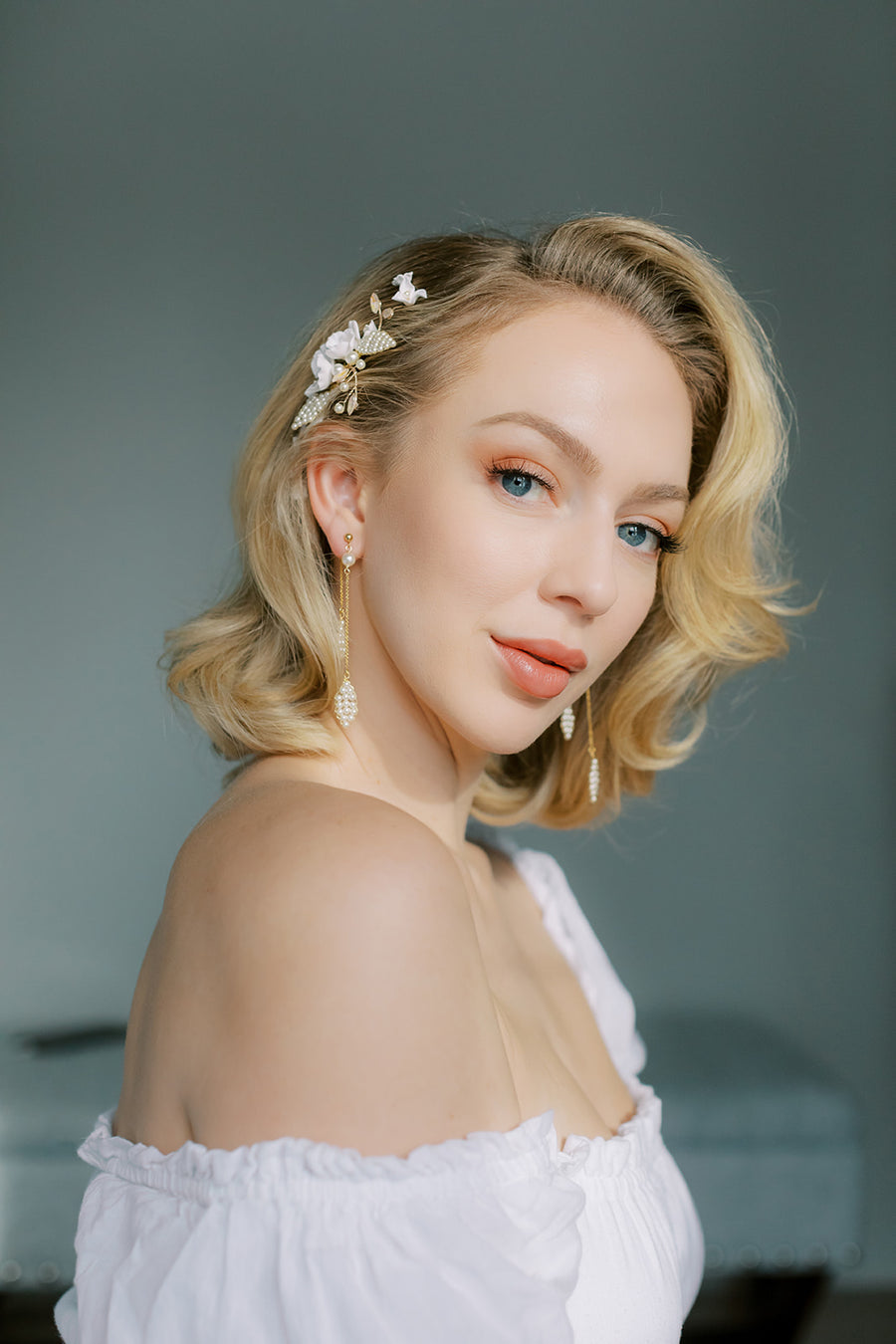 Los Angeles bride with hair back to one side wearing long gold and pearl drop bridal earrings.