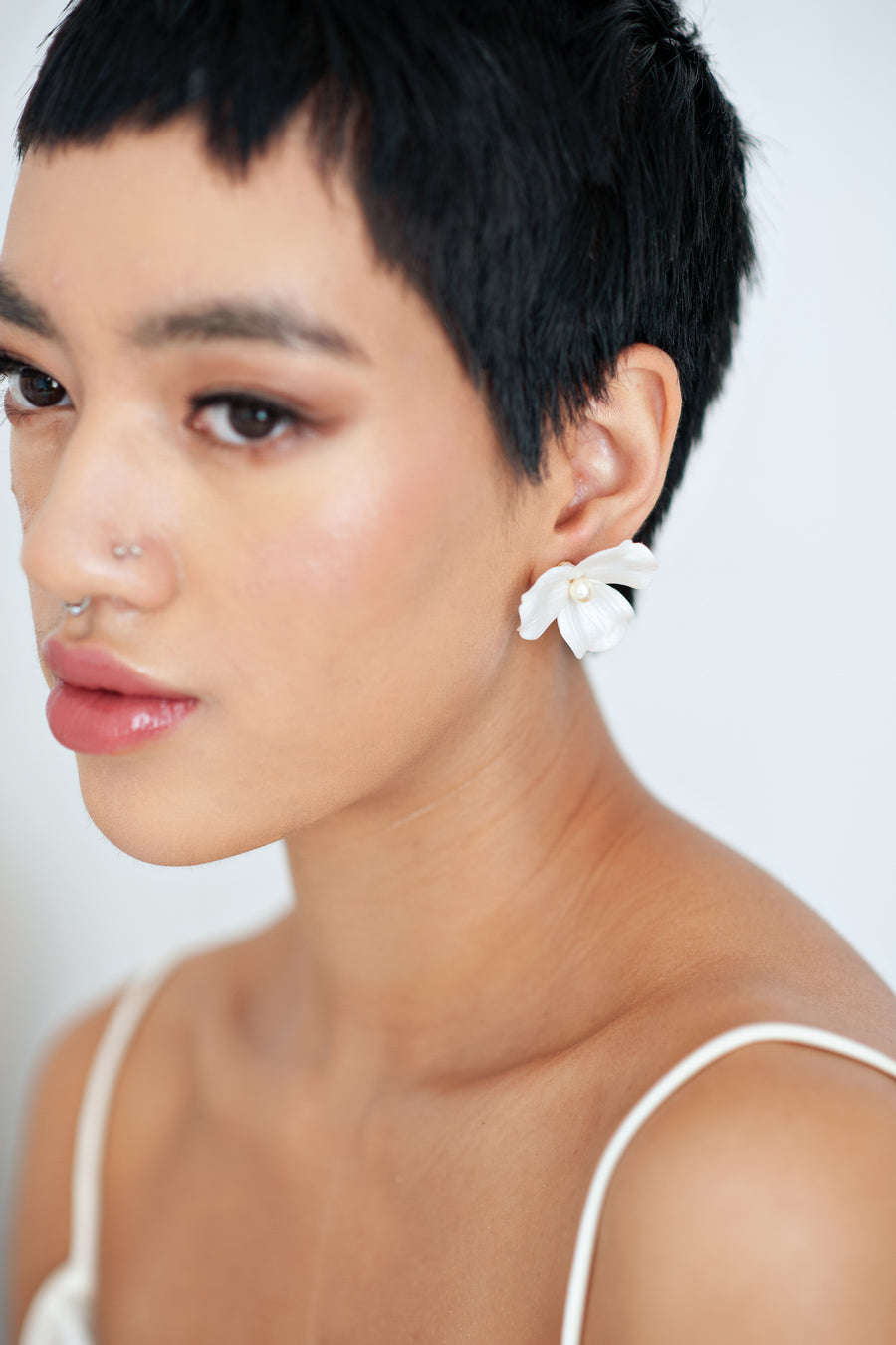 Bride wearing luxury pearlized flower stud wedding earrings by Joanna Bisley Designs.