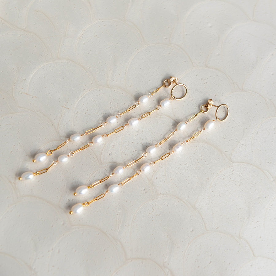 A closeup picture picture of long Pearl wedding earrings for the modern bride. Handcrafted in Calgary by Joanna Bisley Designs. 