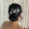 A bride with dark hair wearing a set of our bridal pins with pearls and flowers 
