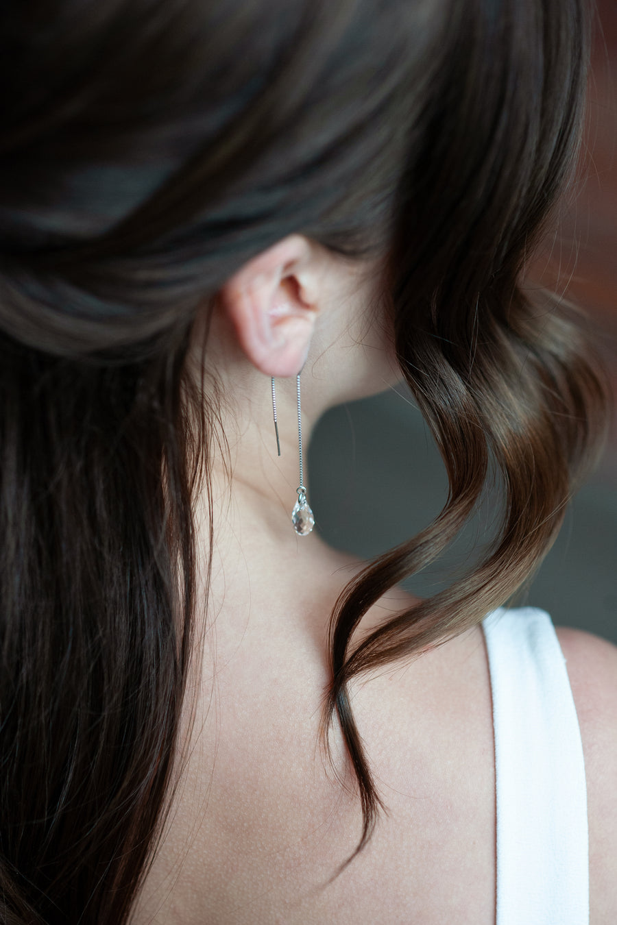 Bride wearing long silver drop crystal wedding earrings by Joanna Bisley Designs.