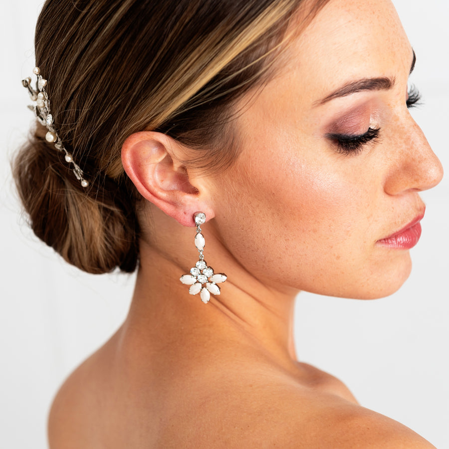 A bride looking over her shoulder wearing a Swarovski Crystal and gold statement bridal earring. 