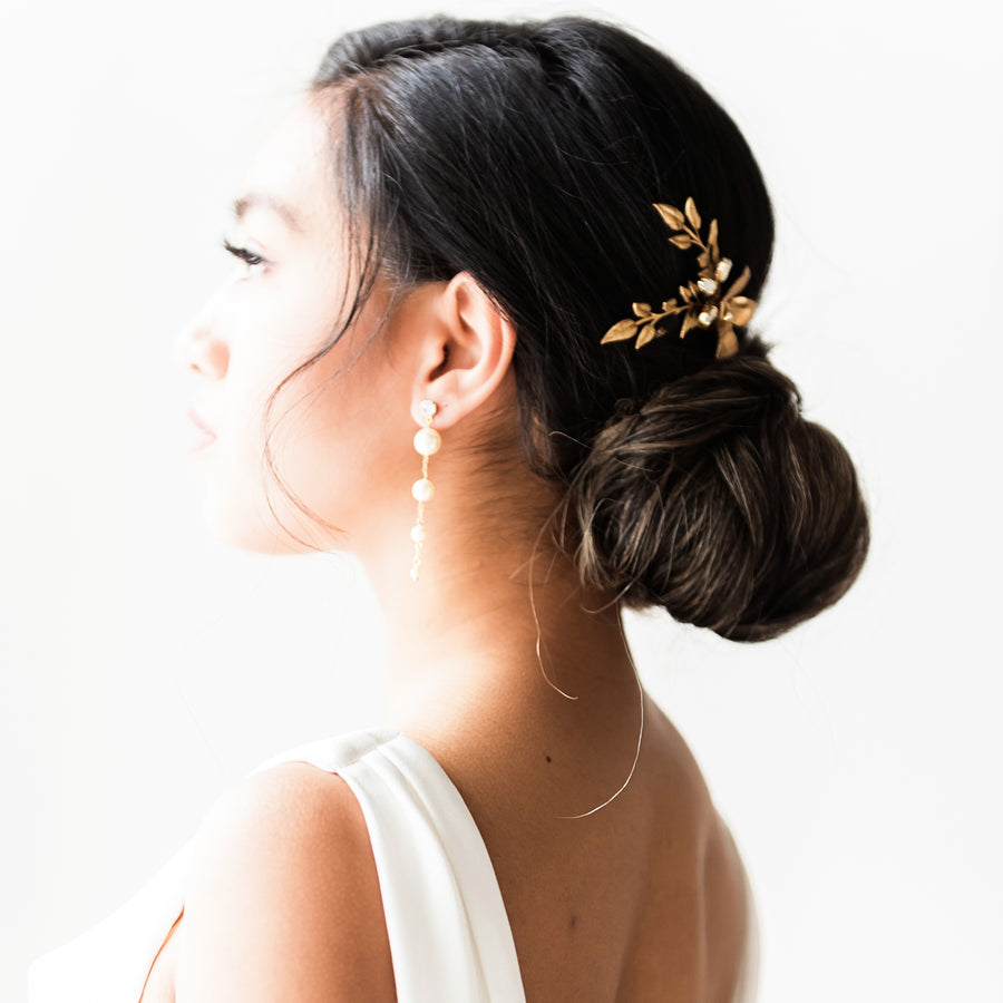 Bride wearing an updo wearing bridal comb and long pearl bridal earrings.