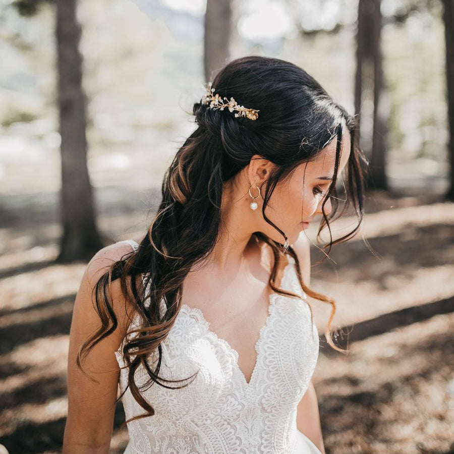 A bride with half up half down bridal hairstyle wearing a pair of pearl hoop bridal earrings by Joanna Bisley Designs.