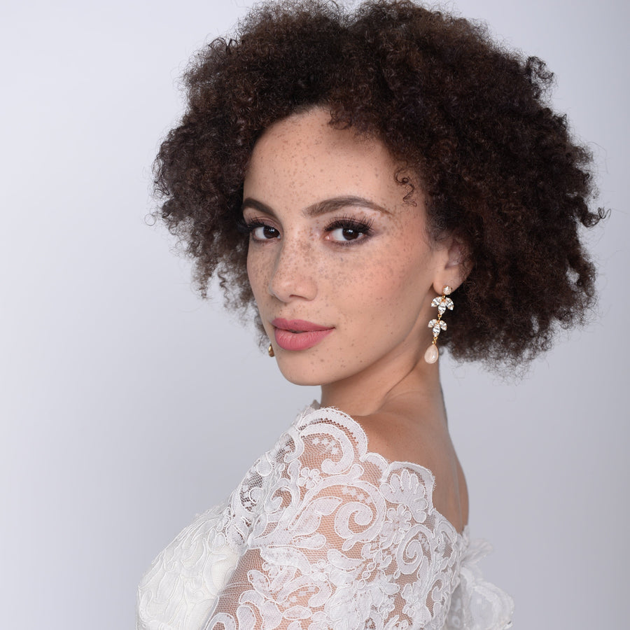 Modern bride wearing a pair of blush crystal statement bridal earrings.