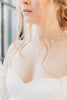 Bride wearing delicate freshwater pearl wedding necklace with sweetheart neckline.