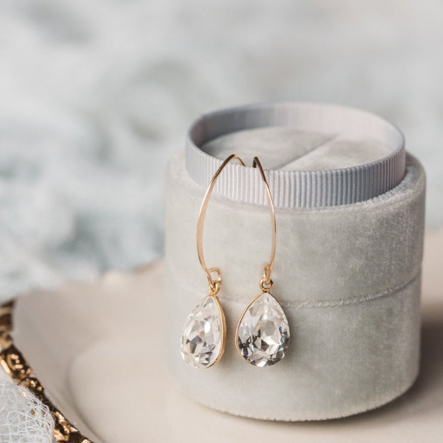 A pair of crystal drop earrings on a long gold earwire.